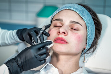 Young woman having permanent makeup on lips in beautician salon, closeup