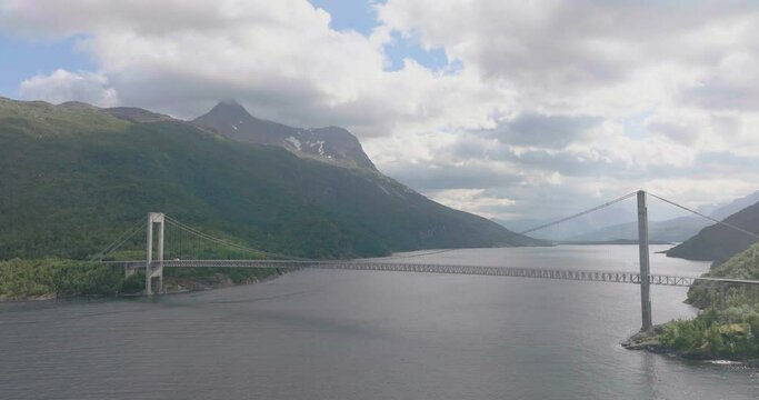 Panoramic aerial shows Skjomen bridge over fjord in dramatic landscape