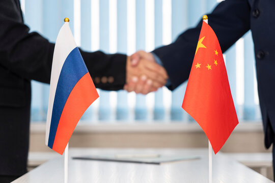 Political flags of russia and chinese on table in international negotiation room. concept of negotiations, collaboration and cooperation of countries. agreement between governments.