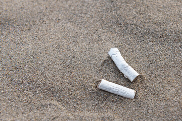 Cigarette butts on the sand. Environmental pollution.