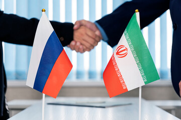 Political flags of russia and iran on table in international negotiation room. concept of negotiations, collaboration and cooperation of countries. agreement between governments. - obrazy, fototapety, plakaty