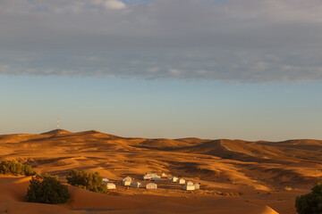 Fototapeta na wymiar Camp of tents in the Sahara desert. Contemporary luxury glamping camp in Morocco
