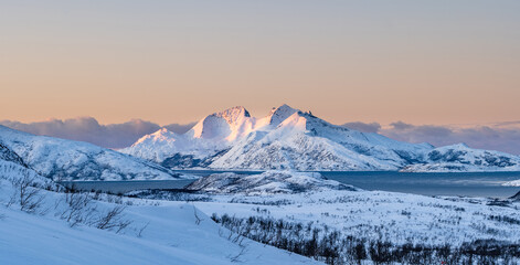 Norwegian mountains and fjord near Tromso photographed at golden hour in winter