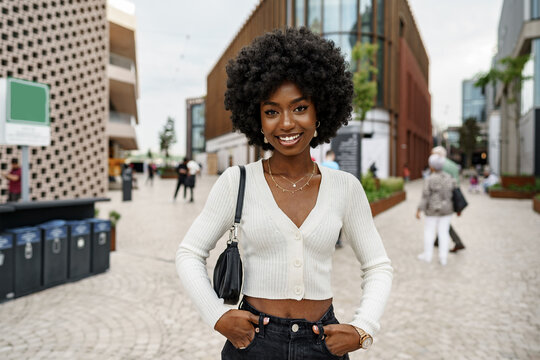 Portrait of young african woman with hairstyle smiling in urban background