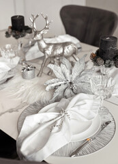 Details of luxury christmas table setting in silver and gray colors prepared for festive dinner