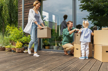 Family with cardboard boxes moving to new house