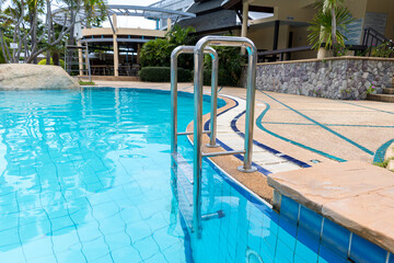 Ladder stainless handrails for descent into swimming pool. Swimming pool with handrail . Ladder of...