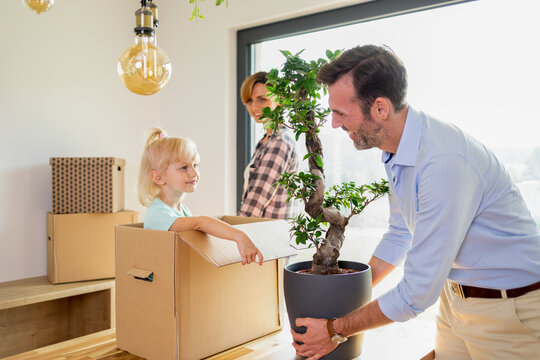 Joyful moments of move to new home family opening boxes together