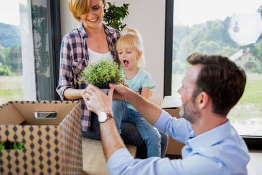 Joyful moments of move to new home family opening boxes together