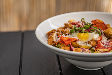 Caesar salad with egg on a white plate