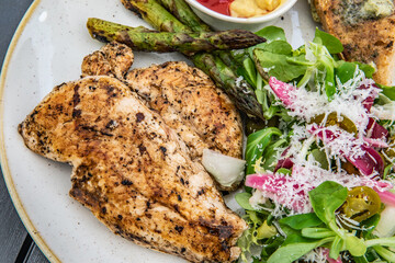 Grilled chicken fillet with asparagus, mustard, ketchup, salad and toast