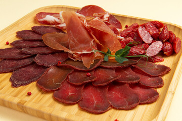 Various meat delicacies on a wooden board.