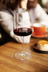 Single glass with red wine on dinner table. 