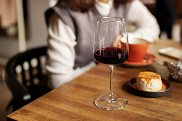 Single glass with red wine on dinner table. Still life of alcoholic drink