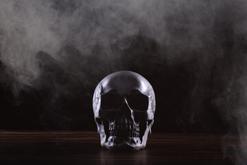Halloween human skull on an old wooden table over black background. Shape of skull bone for Death...