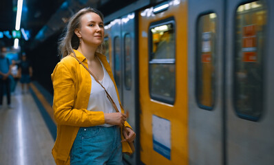 Woman is waiting for the train in the subway.