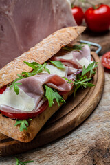 submarine sandwiches with ham, tomato, parmesan and arugula. Food recipe background. Close up