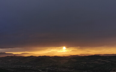 hdr Il sole al tramonto illumina le montagne in un cielo di nuvole nere