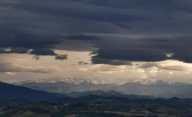 Nuvole bianche e nuvole nere tempestose sopra le montagne le colline e le valli