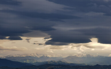 Fototapeta na wymiar Nuvole bianche e nuvole nere tempestose sopra le montagne le colline e le valli