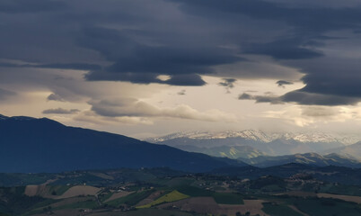 Nuvole bianche e nuvole nere tempestose sopra le montagne le colline e le valli