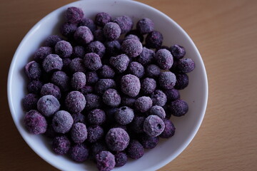 Frozen blueberries in a white bowl.