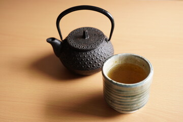 Black iron asian teapot with green tea