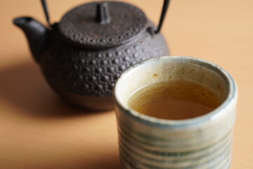 Close up of Black iron asian teapot with green tea