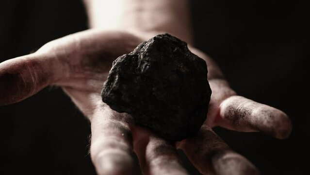 A lump of coal in a miner's hand.