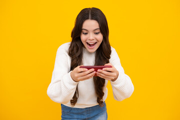 Excited teenager girl 12, 13, 14 years old with smart phone. Hipster teen girl types message on cellphone, enjoys mobile app. Kid hold smartphone texting in online social media. Internet addiction.