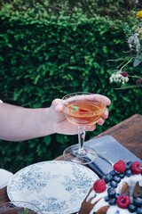Main tenant un cocktail lors d'un repas dans un jardin