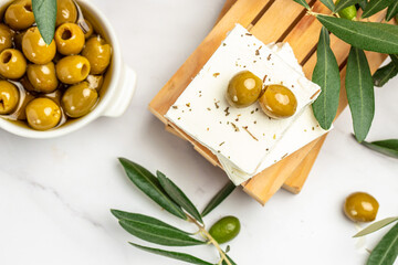 Feta cheese with olives and olive oil sauce in bowl on white background. Traditional Greek homemade cheese. place for text, top view
