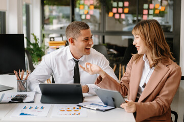 Male discussing new project with male colleague. Mature woman talking with young man in office.
