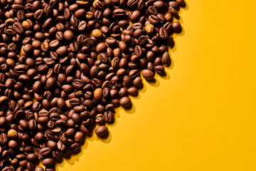 Roasted coffee beans on yellow background