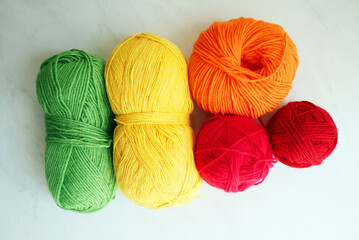 Composition with rainbow yarn balls on light background  