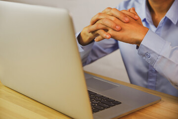 Close-up of businessman hand using a laptop on the desk, making decisions
