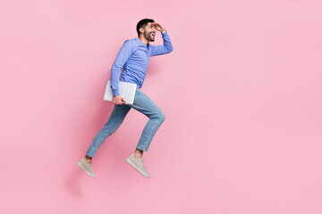 Fototapeta na wymiar Full length photo of exited pretty arab guy dressed blue pullover jumping holding device empty space isolated pink color background
