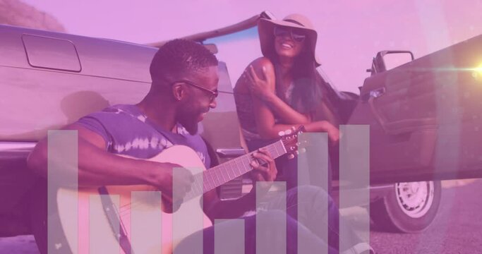 Animation of audio eq meter over happy diverse couple sitting by car on roadside, man playing guitar