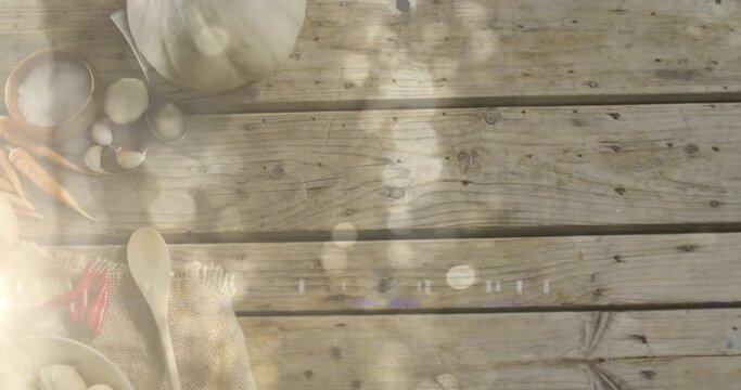 Animation of light spots over vegetables and spices on wooden background