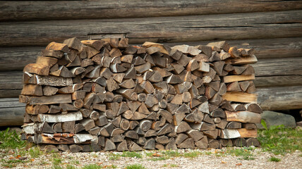 a small log with firewood near an old village house of the 19th century,