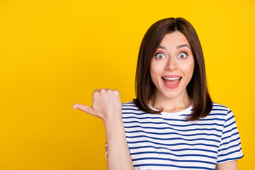 Closeup photo of young gorgeous funny woman shocked surprised directing empty space crazy news isolated on yellow color background