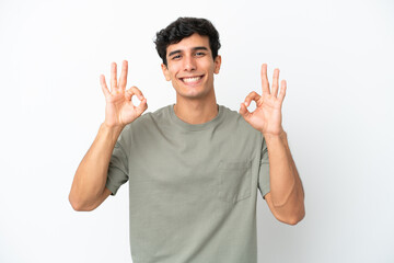 Fototapeta premium Young Argentinian man isolated on white background showing ok sign with two hands