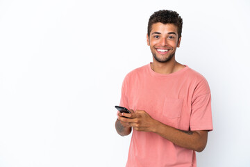 Young handsome Brazilian man isolated on white background sending a message with the mobile - obrazy, fototapety, plakaty