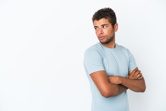 Young handsome Brazilian man isolated on white background keeping the arms crossed