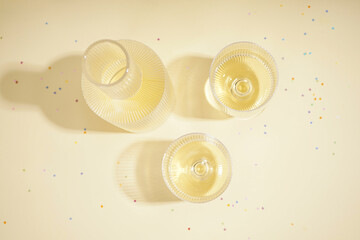 Glasses with champagne placed on table in evening light, top view.