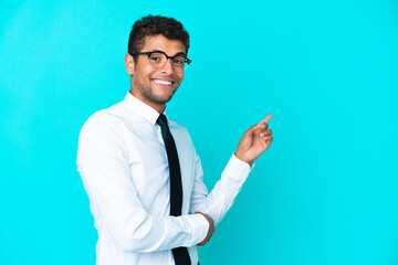 Young business Brazilian man isolated on blue background pointing finger to the side