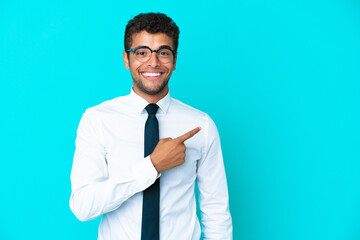 Young business Brazilian man isolated on blue background pointing to the side to present a product