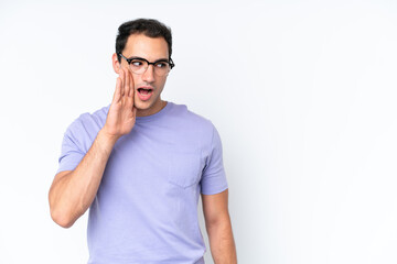 Young caucasian man isolated on white background whispering something with surprise gesture while looking to the side