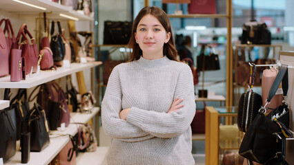 Amazing looking sales lady in the middle of accessories shop posing in front of the camera with...