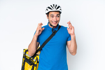 Young caucasian man with thermal backpack isolated on white background with fingers crossing